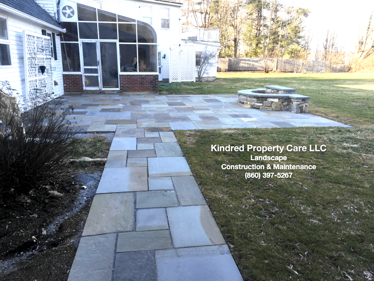 Bluestone patio, walkway, and custom designed fire pit by Kindred Property Care LLC