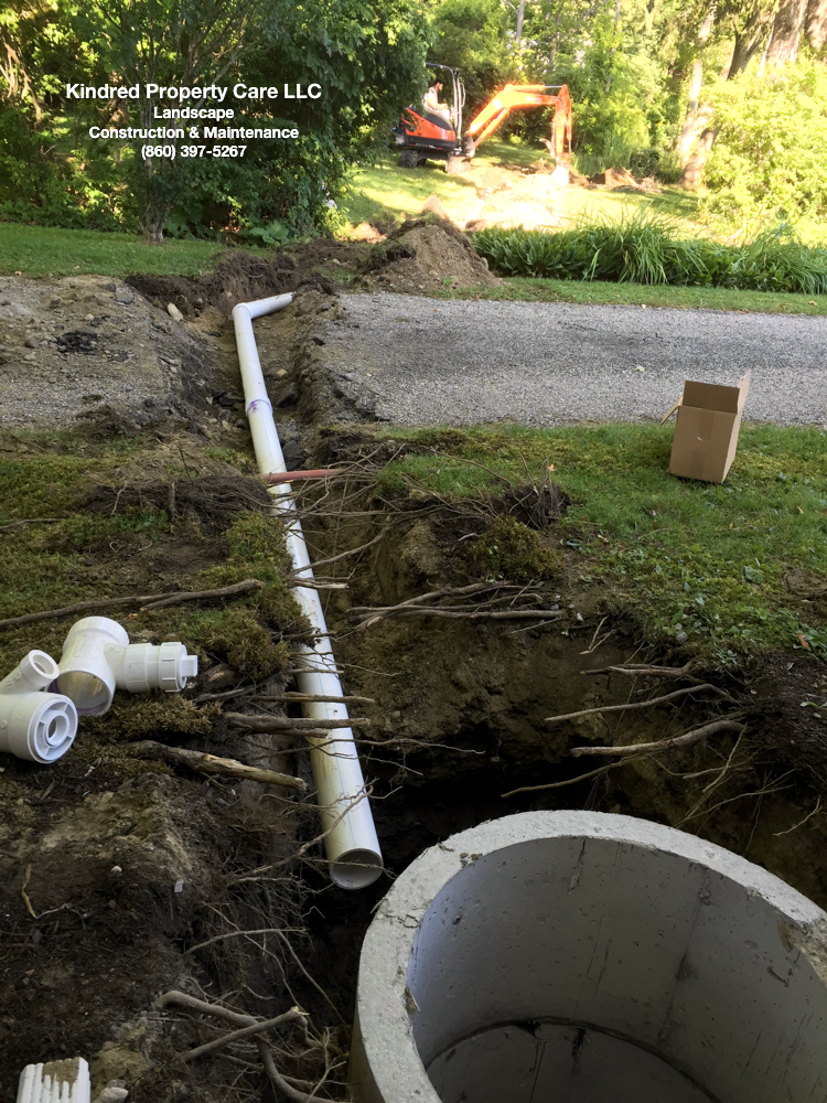 Excavating crew installing sump drainage system